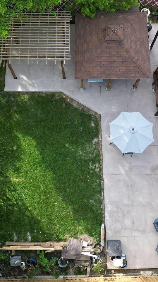 Backyard concrete patio beside a pergola and gazebo