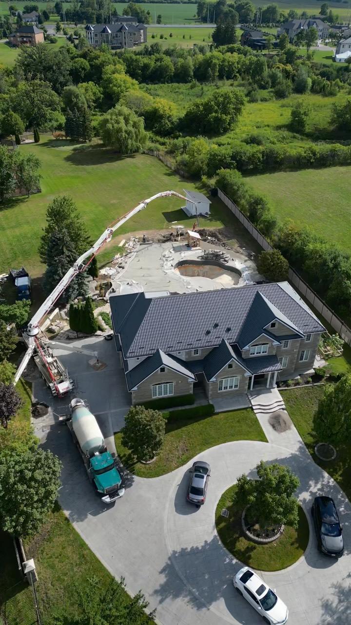 Concrete truck pumping a pour at a country home, from above